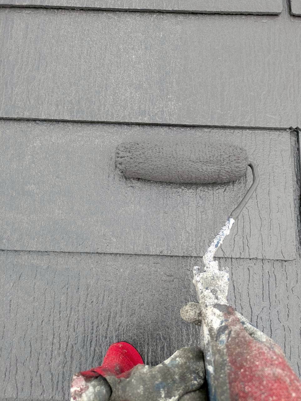 上塗り仕上げ中のスレート屋根